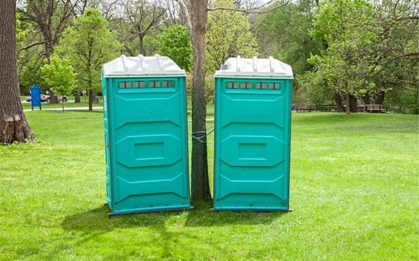 Teal portable restroom units set up for a corporate outdoor event