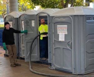 Technician servicing a portable restroom unit on site